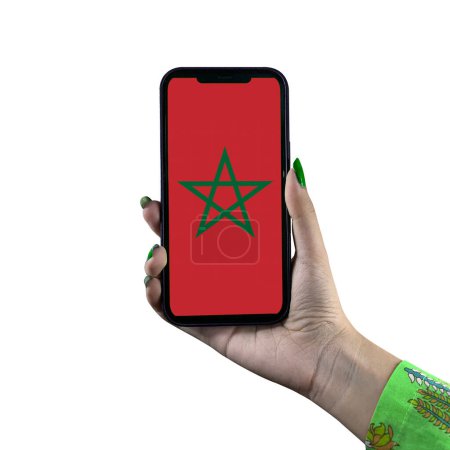 Photo for Morocco Flag display in a smartphone held by a young Asian female or woman's hand. Patriotism with modern cellphone technology display. Isolated on a white background. - Royalty Free Image