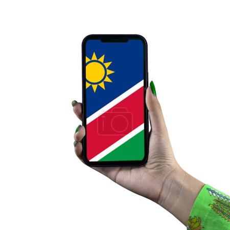 Foto de La bandera de Namibia se muestra en un teléfono inteligente en poder de una joven mujer o mujer asiática. Patriotismo con pantalla moderna de tecnología de teléfonos celulares. Aislado sobre un fondo blanco. - Imagen libre de derechos