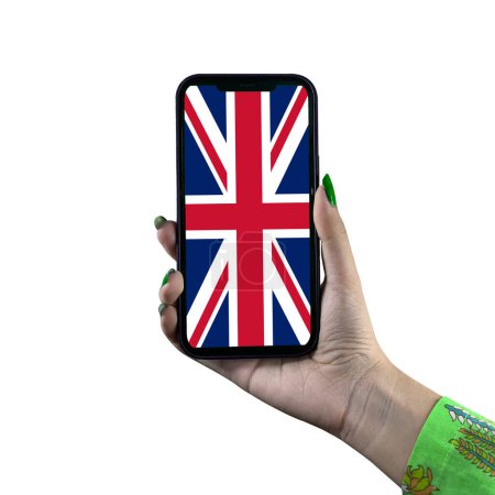 Téléchargez les photos : Le drapeau britannique est affiché sur un smartphone tenu par une jeune femme asiatique ou la main d'une femme. Isolé sur fond blanc. Patriotisme avec affichage moderne de technologie de téléphone portable. - en image libre de droit