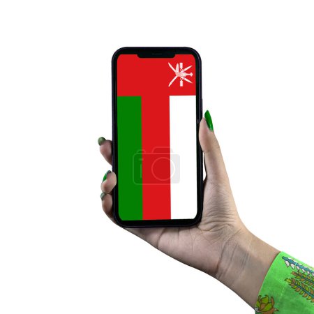 Téléchargez les photos : Oman Affichage du drapeau dans un smartphone tenu par une jeune femme asiatique ou la main d'une femme. Patriotisme avec affichage moderne de technologie de téléphone portable. Isolé sur fond blanc. - en image libre de droit