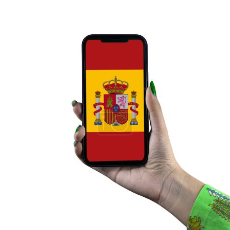 Téléchargez les photos : Le drapeau d'Espagne est affiché sur un smartphone tenu par une jeune femme asiatique ou la main d'une femme. Isolé sur fond blanc. Patriotisme avec affichage moderne de technologie de téléphone portable. - en image libre de droit