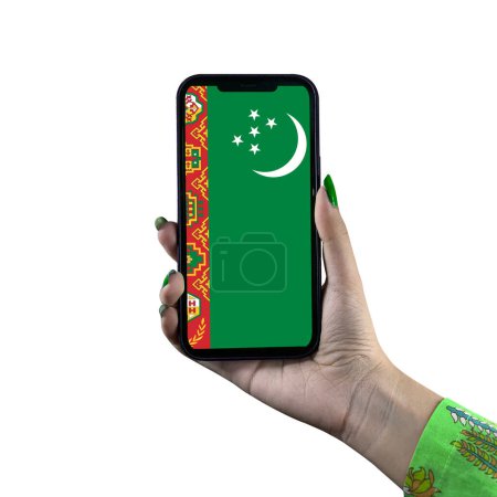 The Turkmenistan flag is displayed on a smartphone held by a young Asian female or woman's hand. Isolated on a white background. Patriotism with modern cellphone technology display.