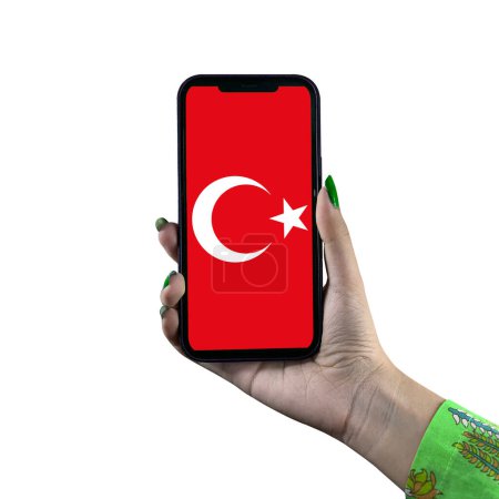 Foto de Una bandera Turkiye (Turquía) se muestra en un teléfono inteligente en poder de una joven mujer asiática o la mano de una mujer. Aislado sobre un fondo blanco. Patriotismo con pantalla moderna de tecnología de teléfonos celulares. - Imagen libre de derechos