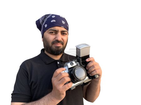 Téléchargez les photos : Un jeune homme avec un bandana arabe pose avec un vieil appareil reflex. Isolé sur fond blanc. - en image libre de droit