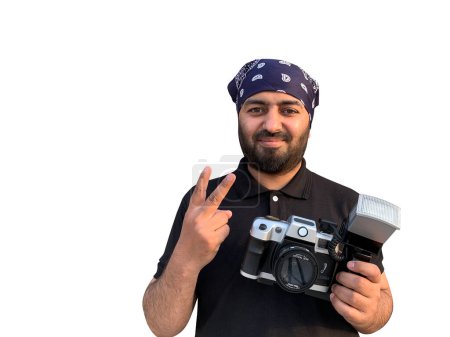 Foto de Un joven con un pañuelo árabe posa con una vieja cámara SLR. Aislado sobre un fondo blanco. - Imagen libre de derechos