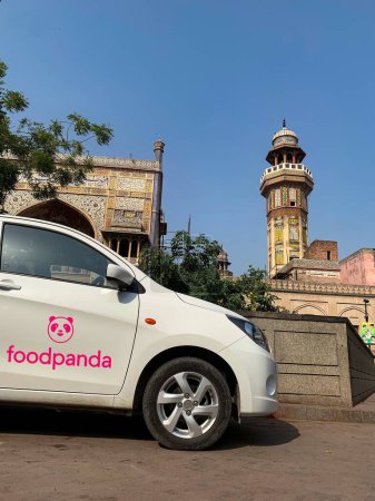 Téléchargez les photos : La cabine ou le taxi FOOD PANDA attendent le cavalier devant la mosquée Wazir Khan. 3 octobre 2023 - en image libre de droit