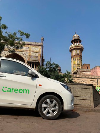 Téléchargez les photos : Cabine ou taxi CAREEM attendant le cavalier devant la mosquée Wazir Khan. 3 octobre 2023 - en image libre de droit