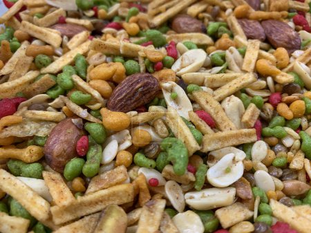 Téléchargez les photos : Fond fait de collation mélange pakistanais, plat salé frit - NIMKO fait de farine, mélangé avec des noix rôties, poivre, légumineuses, épices et pois verts. Snacks épicés pour grignoter. - en image libre de droit