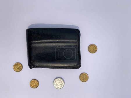 Foto de Cartera negra vista superior con monedas paquistaníes aisladas sobre un fondo blanco. - Imagen libre de derechos