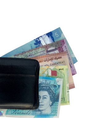 Foto de Vista superior de múltiples monedas de países europeos y árabes con billetera negra aislada sobre un fondo blanco. Incluye Libra, Riyal y Dirham. - Imagen libre de derechos