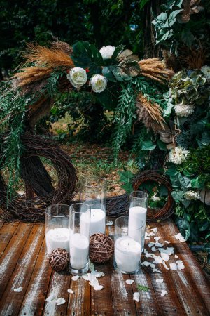 Wedding festive round arch with fresh flowers and candles in Boho style for newlyweds. Creative image for your design or illustrations.