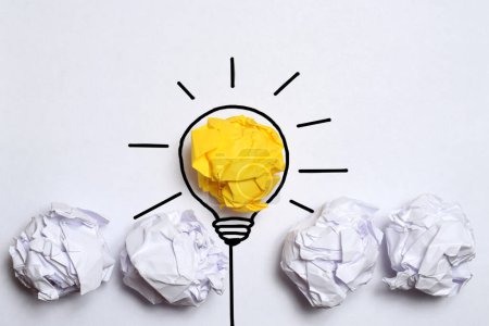 Kreativ denkende Ideen und Innovationskonzept. Papierschrott Kugel gelbe Farbe mit Glühbirnen-Symbol