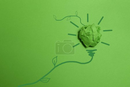 Green crumpled paper light bulb on green background, Corporate Social Responsibility. eco-friendly business and environmental concepts, copy space