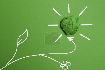 Grüne zerknüllte Papierglühbirne auf grünem Hintergrund, Corporate Social Responsibility. umweltfreundliche Unternehmens- und Umweltkonzepte, Kopierraum