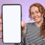 cute woman showing smartphone with white blank screen