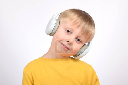 Foto de Retrato de un niño lindo con auriculares sobre un fondo blanco - Imagen libre de derechos