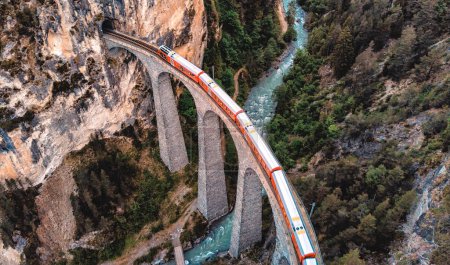 Téléchargez les photos : Landwasserviadukt après le coucher du soleil. Passage du train rouge suisse sur le célèbre pont UNESCO en Suisse, Graubunden, Filisur. - en image libre de droit