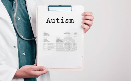 Foto de Doctor sosteniendo almohadilla de papel con autismo de texto - Imagen libre de derechos