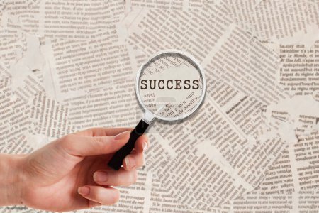 Photo for Hand with Look close with Magnifying glass on success background newspaper - Royalty Free Image