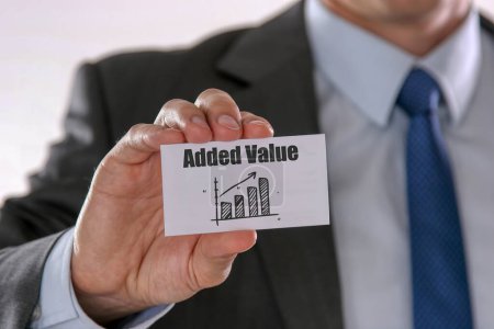 Closeup on businessman holding a card with ADDED VALUE rising arrow and chart, business concept