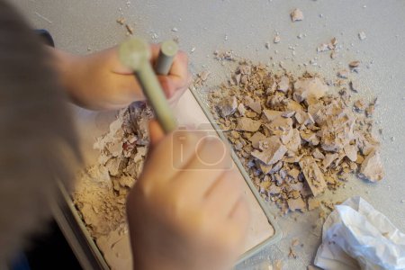 Foto de The child is looking for minerals and stones in a cast of gypsum - Imagen libre de derechos