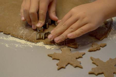 Foto de Las manos de los niños cortan las galletas de la masa con un cortador de galletas - Imagen libre de derechos