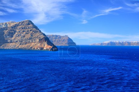 Photo for Typical coast of Santorini, member of the Cyclades group of islands in Greece. In the background the white houses of the village of Oia. - Royalty Free Image