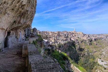 Skyline der Sassi von Matera: Blick auf das historische Zentrum und die Schlucht von Murgia Materana aus einer in den Kalkstein gegrabenen Gasse.
