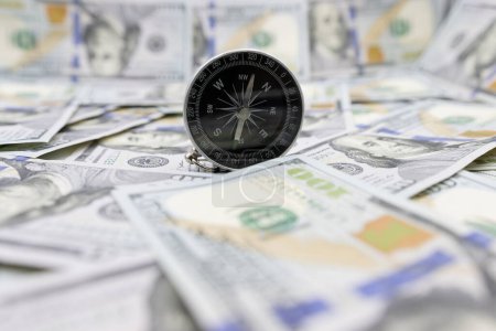 Photo for Classic navigational compass on the background of one hundred dollar bills. Compass and dollars - Royalty Free Image