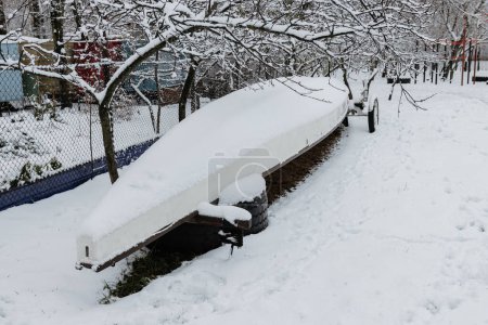 Photo for Multi-seat kayak covered in snow. Storage of kayaks and kayaks in winter. - Royalty Free Image