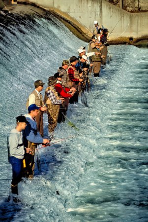 Téléchargez les photos : Les pêcheurs de truites se rassemblent à un endroit prisé le long de la base du barrage pour le 1er mars, jour d'ouverture de la saison de la truite du Missouri, au Bennett Spring State Park, près du Liban, Missouri. Bennett Spring est l'un des quatre parcs aquatiques froids du Missouri où se trouvent des truites arc-en-ciel. - en image libre de droit