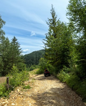 Téléchargez les photos : Un homme en casque et en salopette parcourt un sentier forestier en VTT. Concept vacances et aventure. Photo de haute qualité - en image libre de droit