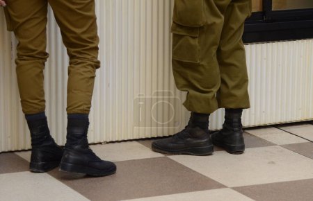 Botas de soldado en los pies de un soldado israelí. Concepto: Soldados IDF - Fuerzas de Defensa de Israel (Tzahal), soldados israelíes, ejército israelí. Hombres y mujeres soldados, igualdad de género