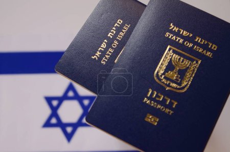 Ein internationaler biometrischer Reisepass eines irakischen Staatsbürgers, ein Reisepass eines neuen Einwanderers vor dem Hintergrund der Flagge Israels. TRANSLATION: Teudat ole. Konzept: Einwanderung nach Israel, 
