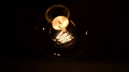 Photo for Tesla glass light bulb in the dark. Incandescent thread. Concept: energy saving, blackout, lack of electricity, new idea, light in the dark - Royalty Free Image
