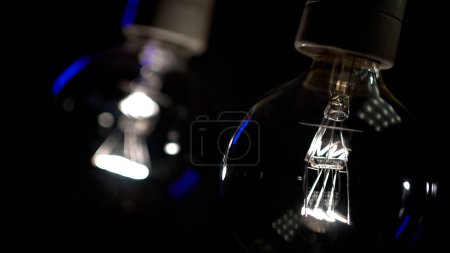 Photo for Tesla glass light bulb in the dark. Incandescent thread. Concept: energy saving, blackout, lack of electricity, new idea, light in the dark - Royalty Free Image