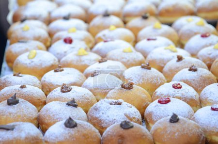 Photo for Fresh donuts with chocolate, jam at the bakery display for celebration. Sufganiyot - Israeli Donuts. Selective focus. Symbol of sweet Hanukkah donut - Sufganiyah. - Royalty Free Image
