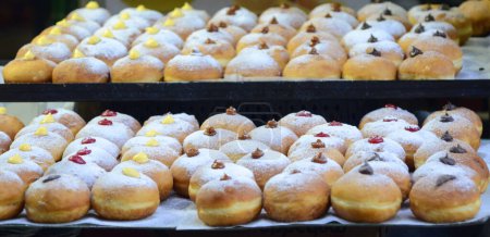 Foto de Rosquillas frescas con chocolate, mermelada en la exhibición de panadería para la celebración. Sufganiyot - Israeli Donuts (en inglés). Enfoque selectivo. Símbolo de donut de Janucá dulce - Sufganiyah. - Imagen libre de derechos