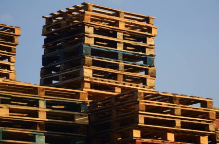 Téléchargez les photos : Wooden boxes and pallets. Many pallets stacked in stock, warehouse pallets, sky background - en image libre de droit