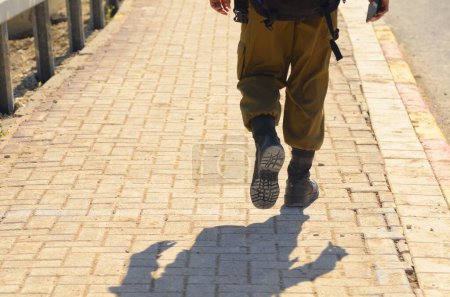 Foto de Israeli soldier without a face. Only boots. Soldier walking on asphalt. Soldiers IDF - Israel Defense Forces (Tzahal), IsraelI soldiers, Israeli army - Imagen libre de derechos