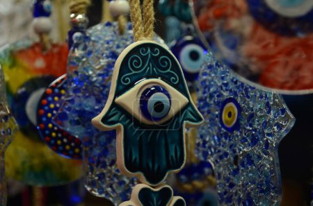 Photo for Nazar in market. Blue and red Fatima eye close-up protective amulet against evil eye. Israeli and turkish souvenir. decorative glass blue souvenirs in the form of an eye - Royalty Free Image