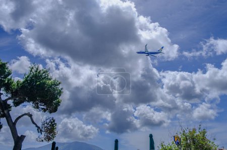 Foto de Corfú, Grecia - 15 de abril de 2023: Ryanair Boeing 737 despega por debajo de las nubes ominosas y el cielo azul del Aeropuerto Internacional de Corfú - Imagen libre de derechos