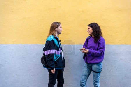 Foto de Young friends talking standing outdoors on the street. Friendship concept. - Imagen libre de derechos