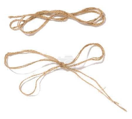 Foto de Una madeja de cuerda de cordel marrón sobre un fondo blanco aislado, vista superior. Embalaje natural - Imagen libre de derechos