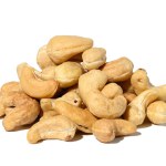 Heap of roasted cashew nut on white isolated background, close up
