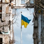 Flag of Ukraine against the background of a destroyed building in Ukraine