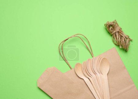 Téléchargez les photos : Cuillères en bois, sac en papier et corde de remorquage sur fond vert, vue sur le dessus - en image libre de droit