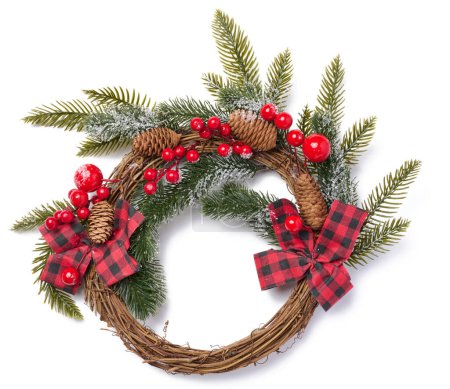 Corona de Navidad hecha de ramas de abeto, cinta y bayas rojas
