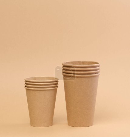Foto de Pila de vasos de cartón desechables de papel marrón sobre fondo beige - Imagen libre de derechos