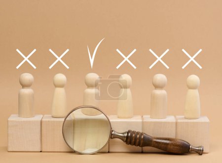 Foto de Wooden figures of men stand on a beige background and a wooden magnifying glass. Recruitment concept, search for talented and capable employees, career growth - Imagen libre de derechos